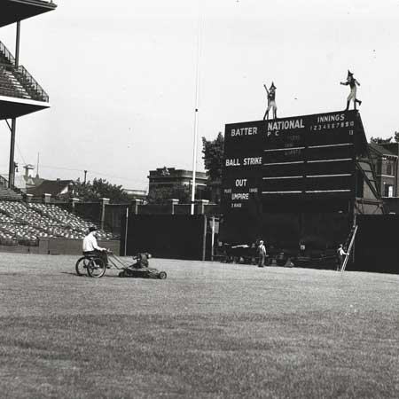 Wrigley's Doublemint elves play atop the scoreboard, temporarily in left field, during 1937 construction
